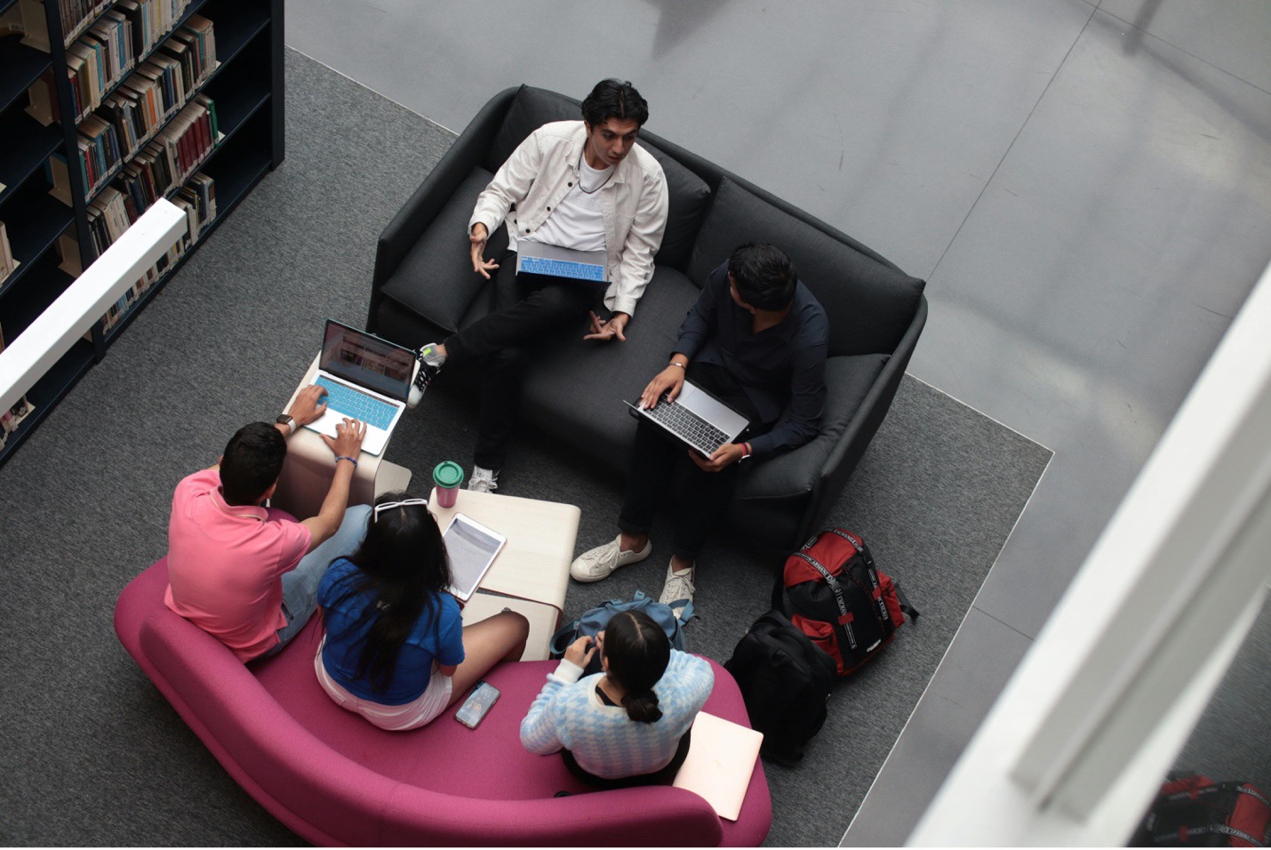 College students with laptops gathered at a library to study College students with laptops gathered at a library to study